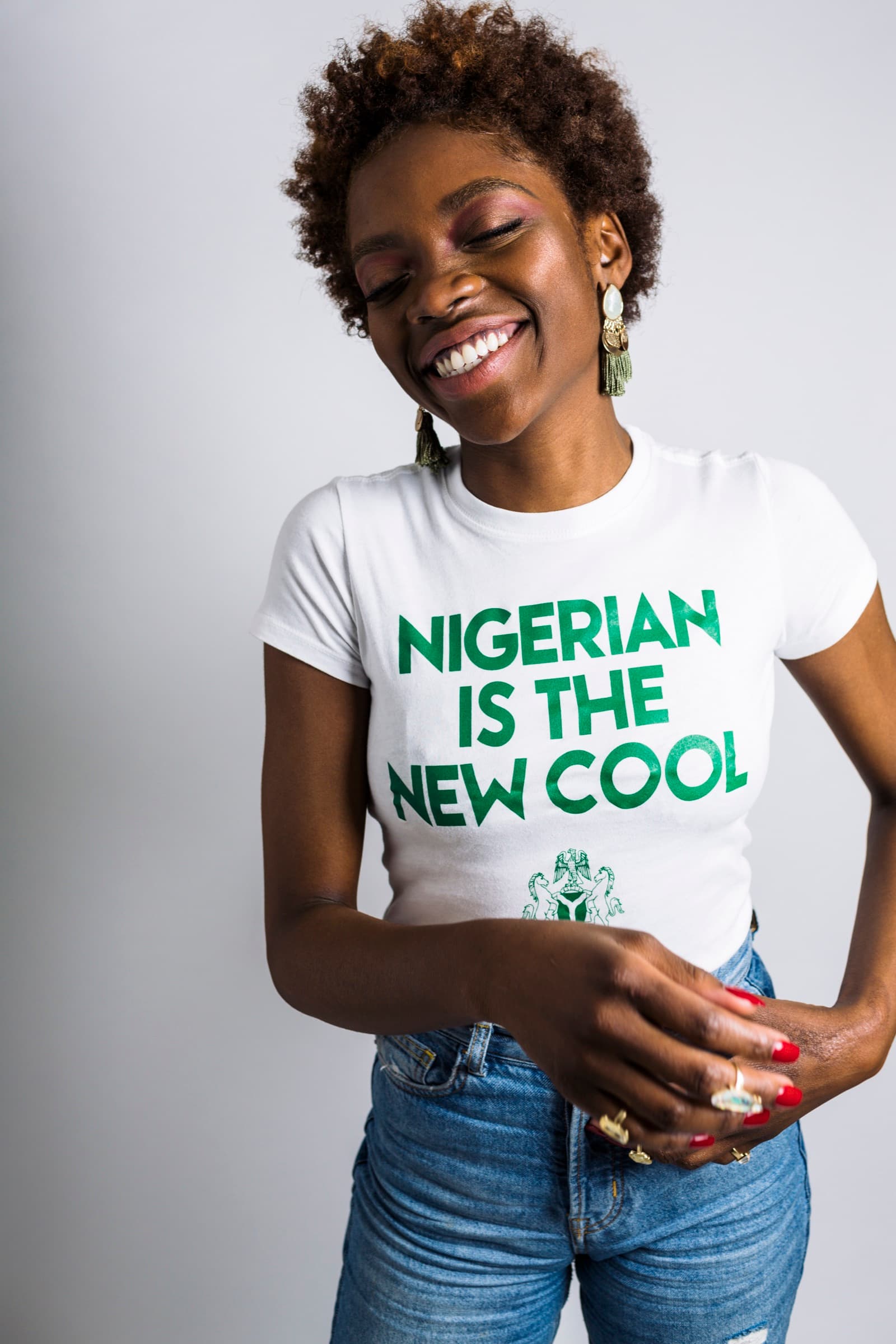 Smiling NITNC model in a white Nigerian Is The New Cool tee